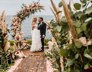 bride and groom standing on woodend deck surrounded by flowers at cuvier park, la jolla