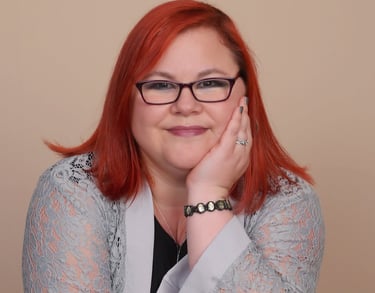 Elizabeth Pressler smiles as she leans casually on the back of a chair.
