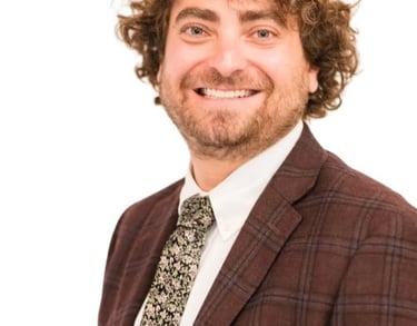 Ari Malman, Denver Attorney; a man in a suit and tie smiling