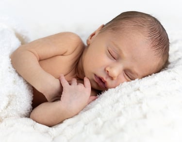 Sessió de fotos newborn a Girona amb una bebè recent nascuda dormint en estudi fotogràfic