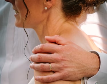 Marié tenant l'épaule de la marié avec sa bague au doigt