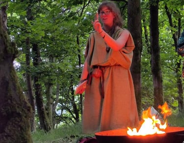 a woman in a robe is standing in front of a fire pit