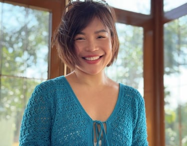 a woman in a blue sweater is smiling and holding a drink