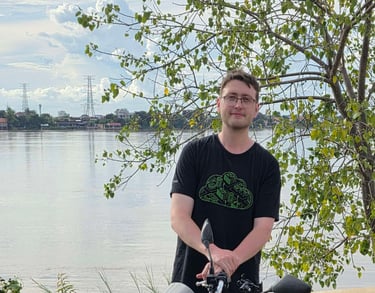 Jamie Blair beside a motorbike at the Mekong River in Phnom Penh, Cambodia