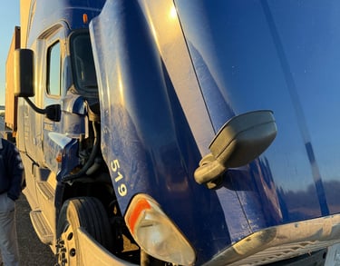 a semi truck with a large blue truck behind it