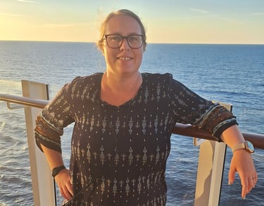 Eine Frau steht auf dem Deck eines Kreuzfahrtschiffes