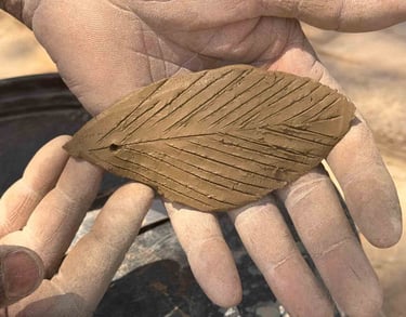 close up picture of a man holding a clay leaf