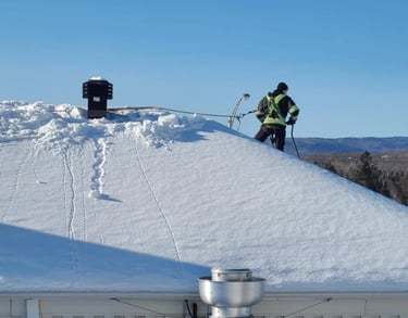 Homme qui déneige toiture avec son harnais (epi)