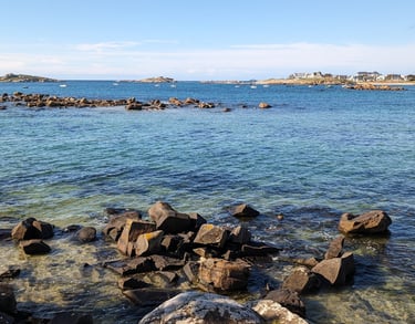 bord de mer, Eau cristalline, rochers et îlots sous un ciel bleu, offrant un paysage côtier apaisant