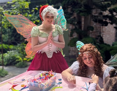 Strawberry and Purple Fairy do a craft with. a child