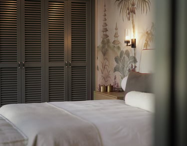 Elegant bedroom with Hamptons-style wardrobes, botanical mural, and soft neutral linens 