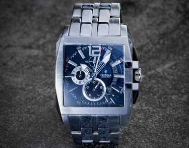 Montre argentée de marque Festina, cadran bleu sur fond pierre noire