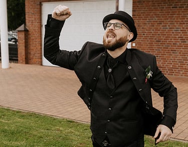 der Bräutigam im alternativen schwarzen Style feiert emotional seinen eigenen Einzug