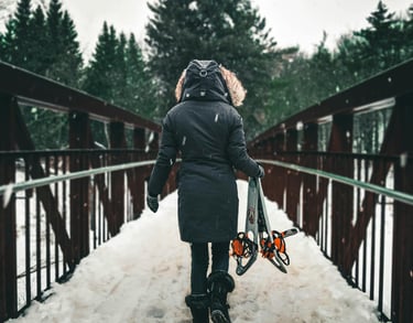 mujer cruzando un puente con nieve