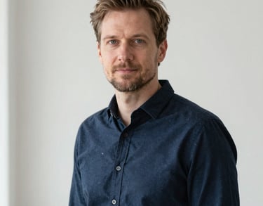 Professional portrait of a man in a dark blue shirt, minimalist and bright background, natural lighting, Northern European / Baltic / Estonian.