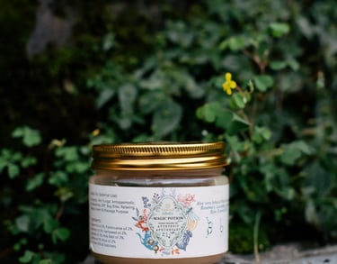 Natural Ayurvedic apothecary skin cream jar on a mossy rock in a lush forest setting.