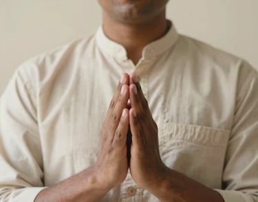 A portrait of a South Asian spiritual practitioner with hands in a mudra position. Wearing a simple cotton tunic, soft focus on the hands, cream background.