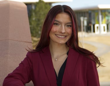 Image of Quesada-Stoner in a maroon suit 
