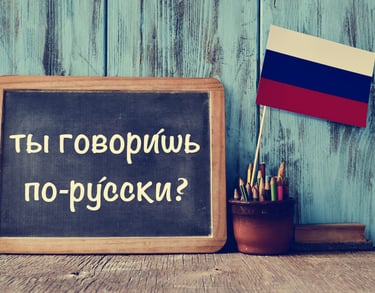 Chalkboard with Do you speak Russian text next to a Russian flag for language learning.