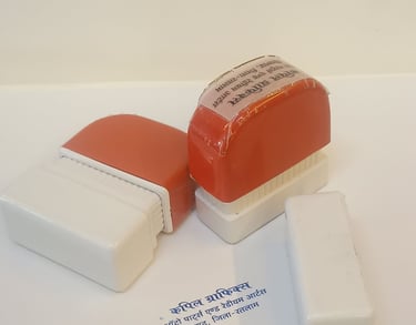 Customized red and white self-inking rubber stamps with blue ink impression on paper.