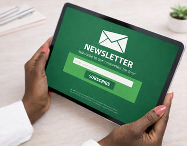 Person holding a tablet displaying a newsletter subscription screen