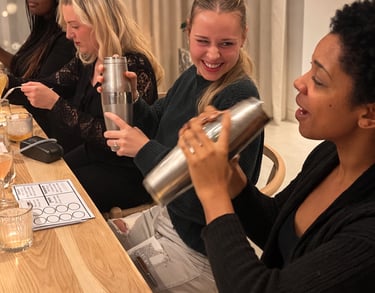 Clients smiling while shaking cocktail tins during a mixology class event.