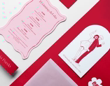 Diferentes elementos que conforman una invitación de boda sobre fondo de color incluyendo invitación ilustrada