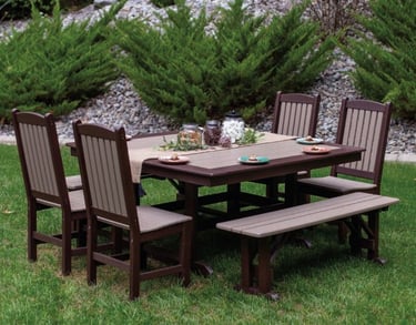 Outdoor poly furniture dining set on lawn with landscaping