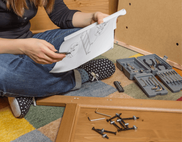 person reviewing instructions with tools scattered around