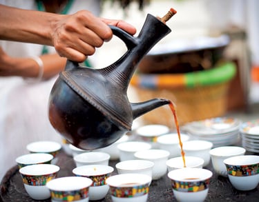 a person pouring coffee into cups in Ethiopia coffee ceremmey