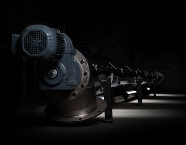 a row of industrial steel pipes with a black background