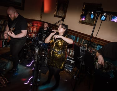 a woman in a gold dress and a man in a black suit and a guitar