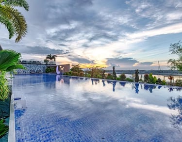 a pool with a view of the ocean and a sunset