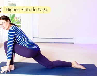 A woman practices a low lunge yoga pose on a blue mat at Higher Altitude Yoga