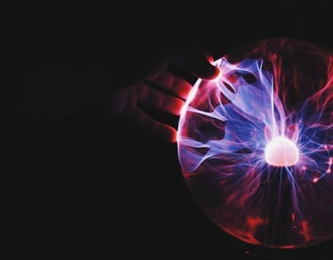 immagine di una mano che toccando una sfera illuminata questa si trasforma in raggi di corrente elet
