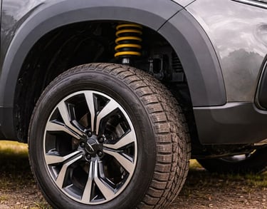 Detalhe da roda e suspensão de SUV, mostrando maior altura do solo e espaço entre pneu e lataria