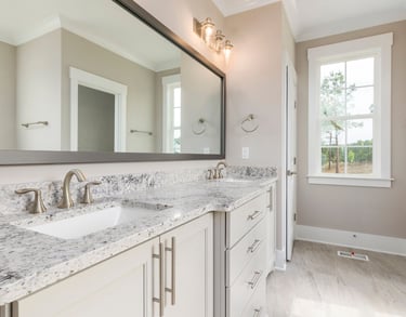 a bathroom with a marble counter top and a mirror