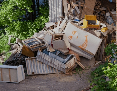alt="Piled junk and broken appliances awaiting removal in Long Island driveway"
