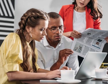 a man and woman sitting at a table with a newspaper