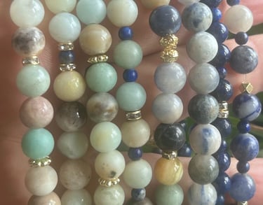 a person holding a bunch of beads and a bracelet