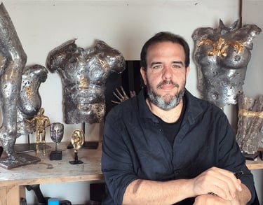 artiste contemporain posant devant ses oeuvres en metal de corps -mikacreations