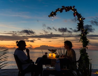 a couple sitting at a table with candles and candles