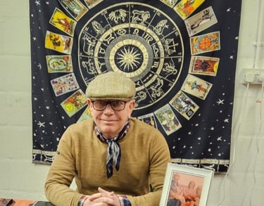 Rob hamilton 4th generation Romani reader, sitting down, astrological signs behind him