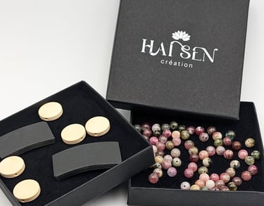 Boîte Hái Sen Création avec perle colorée, cabochon non gravé et plaque noire sans incrustation.