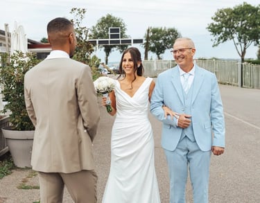 Découverte des mariés : la mariée arrive au bras de son père, souriante, face à son futur époux.