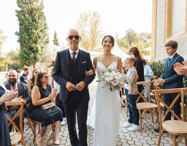 Entrée de la mariée au bras de son père, sous les regards des invités juste avant la découverte.