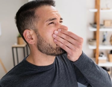 guy holding nose due to sewer odor in home