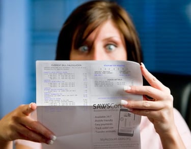 woman looking at a high water bill in shocking manner