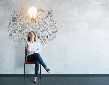 A woman sitting in a chair with a light bulb above her head, representing a brilliant idea.