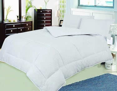 a bed with a white comforter and a blue rug